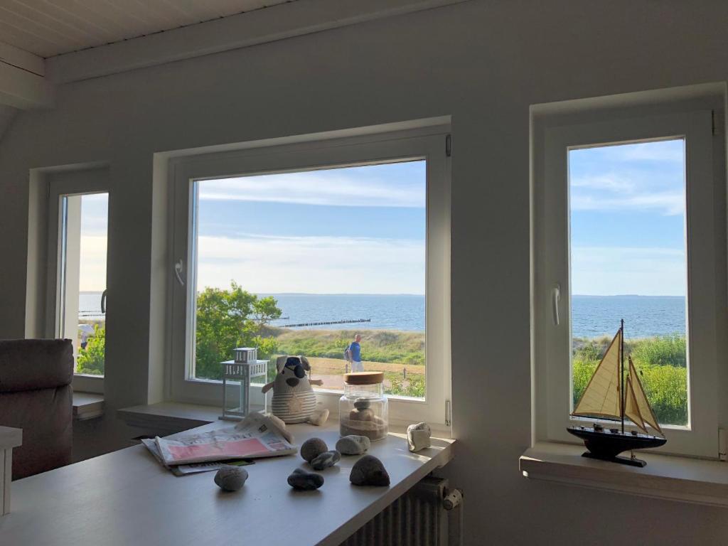 a room with two windows and a table with a view of the ocean at Ferienwohnung Fritzi in Glowe