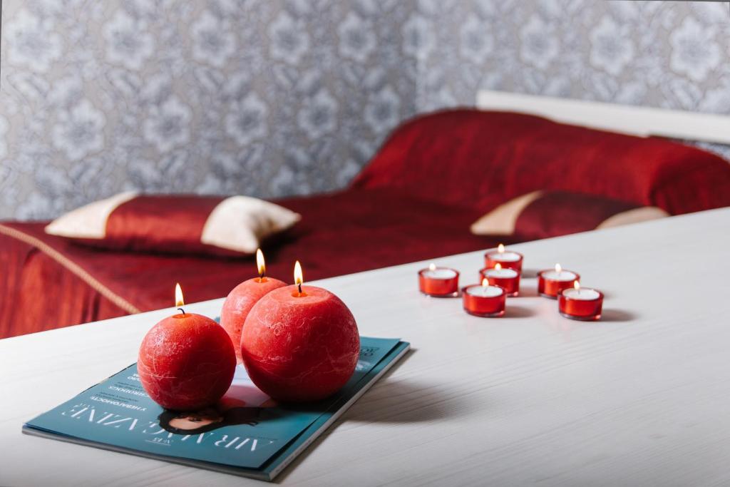 2 pommes rouges avec bougies sur une table dans une chambre dans l'établissement Hotel Dikanka, à Kulikuv