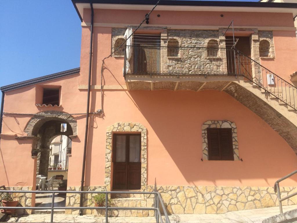TursiにあるCasa Vacanze Tursiのピンクの建物(バルコニー、ドア付)