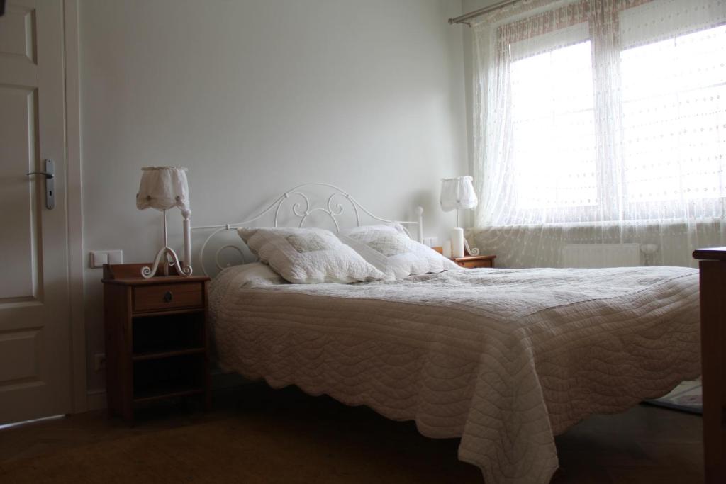 カジミエシュ・ドルニにあるApartament Rodzinnyのベッドルーム1室(白いシーツ付きのベッド1台、窓付)
