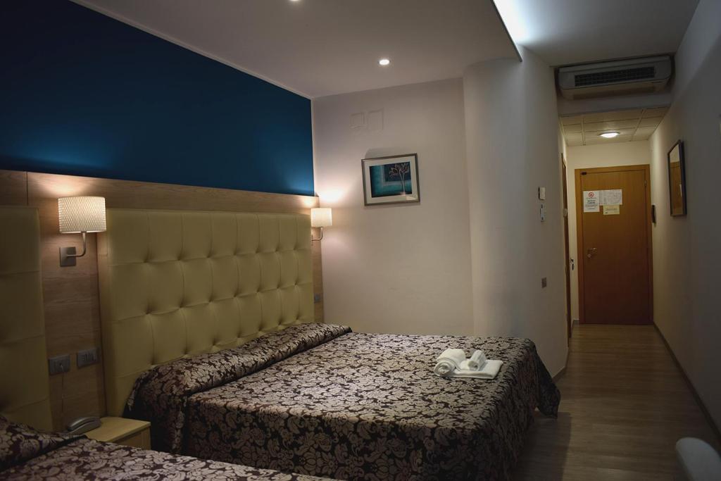 a hotel room with two beds with towels on the bed at Hotel Baffo Rosso in Alba Adriatica