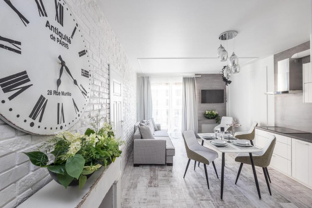 a kitchen and living room with a clock on the wall at Good Time Apartment Business Center in Warsaw