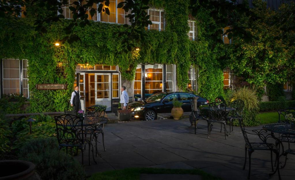 a car parked in front of a building with ivy at Old Ground Hotel in Ennis