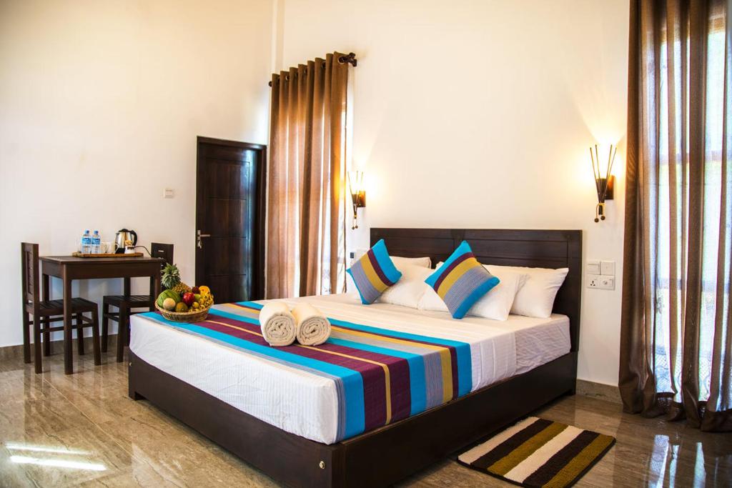 a bedroom with a large bed with two towels on it at Wadula Safari - Yala in Kataragama