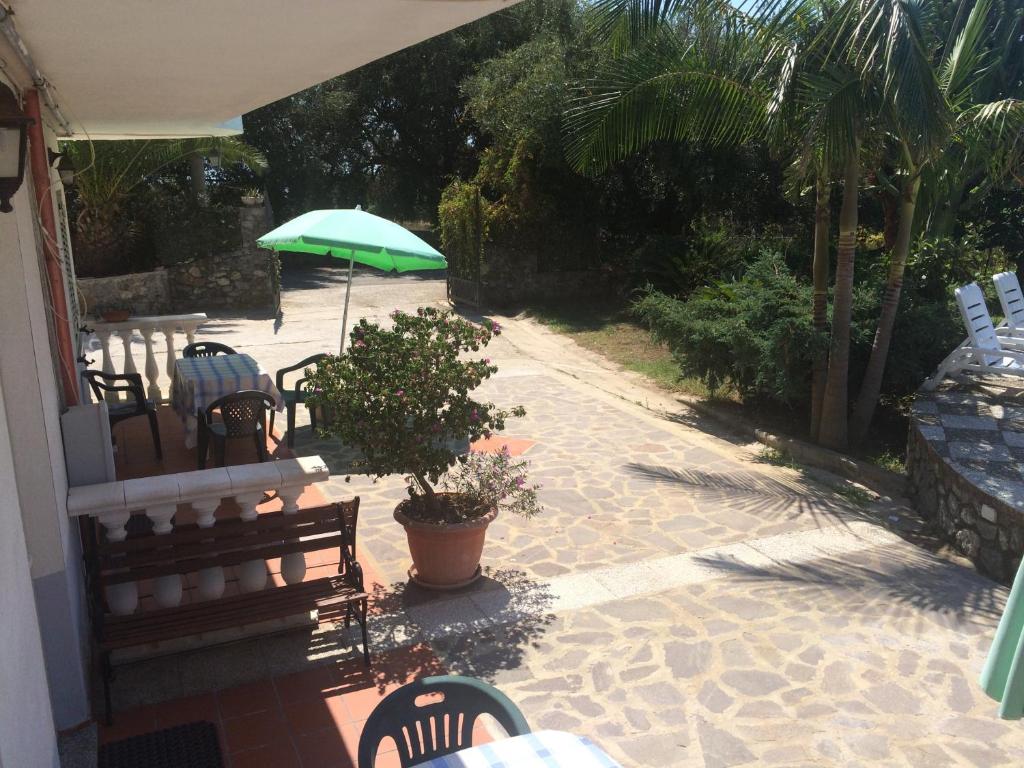 a patio with a bench and an umbrella at Hotel Royal in Coccorino