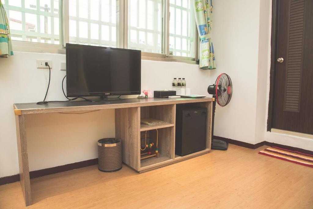 a television on a wooden table in a room at Happy Castle Cottage in Hualien City