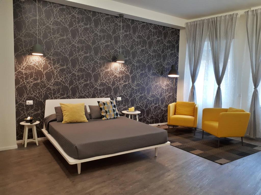 een slaapkamer met een bed en 2 gele stoelen bij Marcona24 in Milaan