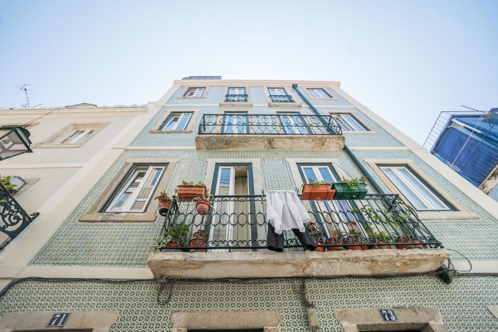 a tall building with a balcony with clothes on it at Madragoa Studios in Lisbon