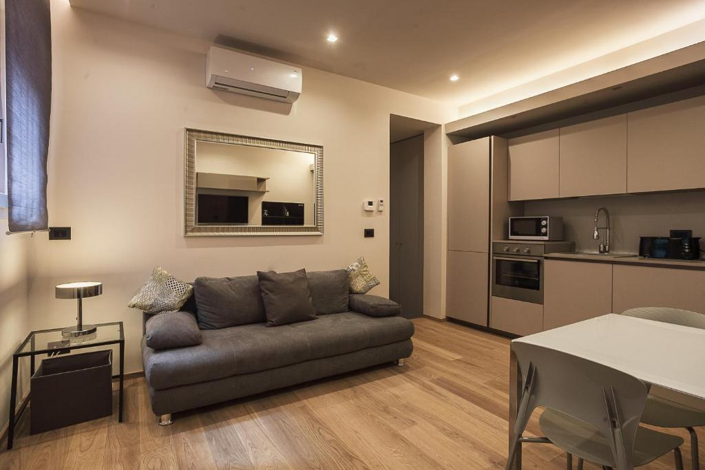 salon z kanapą i kuchnią w obiekcie Residence Rizzoli-Suites Apartments w Bolonii