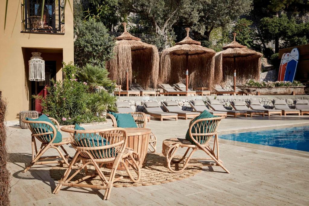 
a patio area with chairs, tables, chairs and umbrellas at Bikini Island & Mountain Port de Soller "Adults only" in Port de Soller
