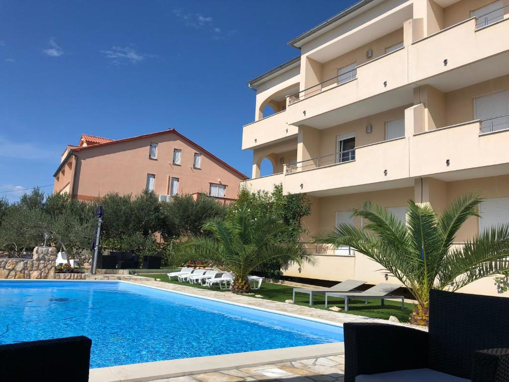 a swimming pool in front of a building at Vila Anica in Barbat na Rabu