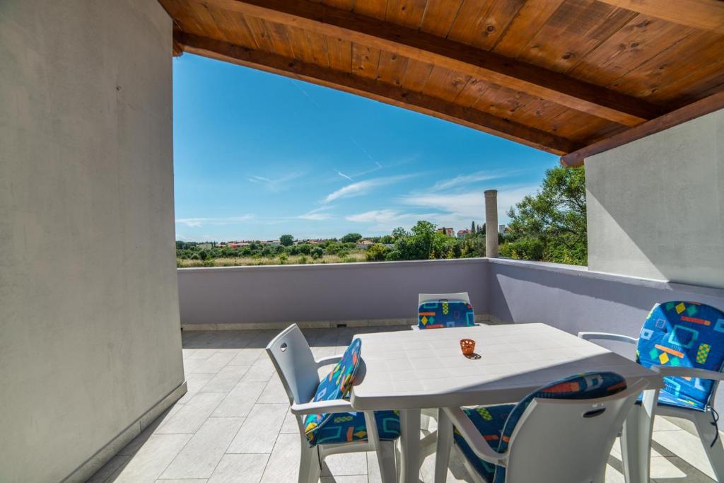 patio ze stołem i krzesłami na balkonie w obiekcie Apartments Đurđa w Fažanie