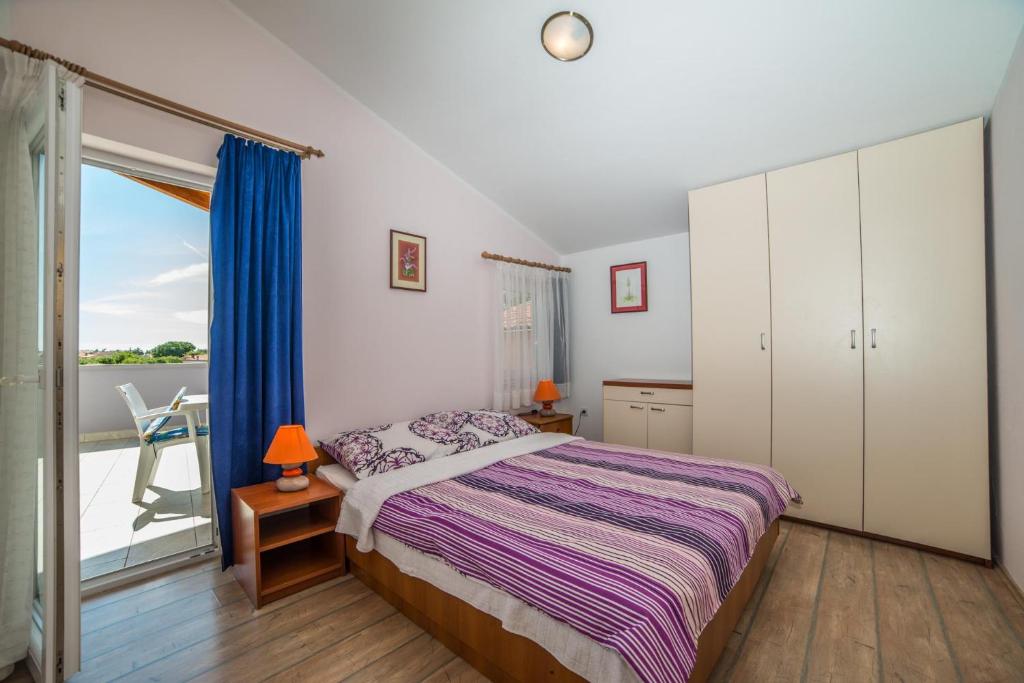 sypialnia z łóżkiem i balkonem w obiekcie Apartments Đurđa w Fažanie