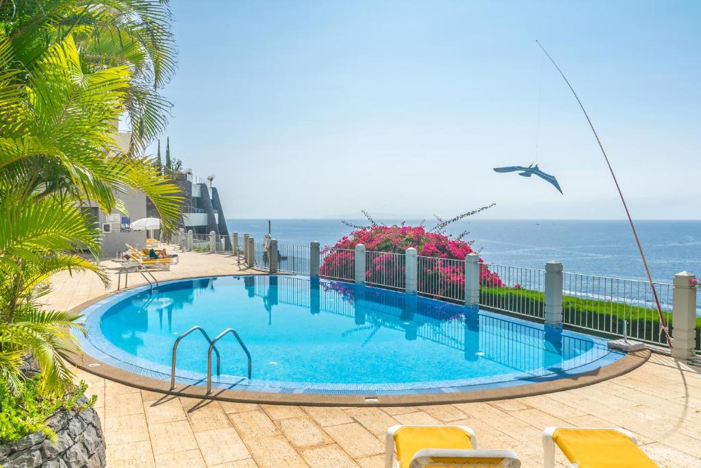 uma piscina com o oceano ao fundo em Arcadas Grand Sea View em Funchal