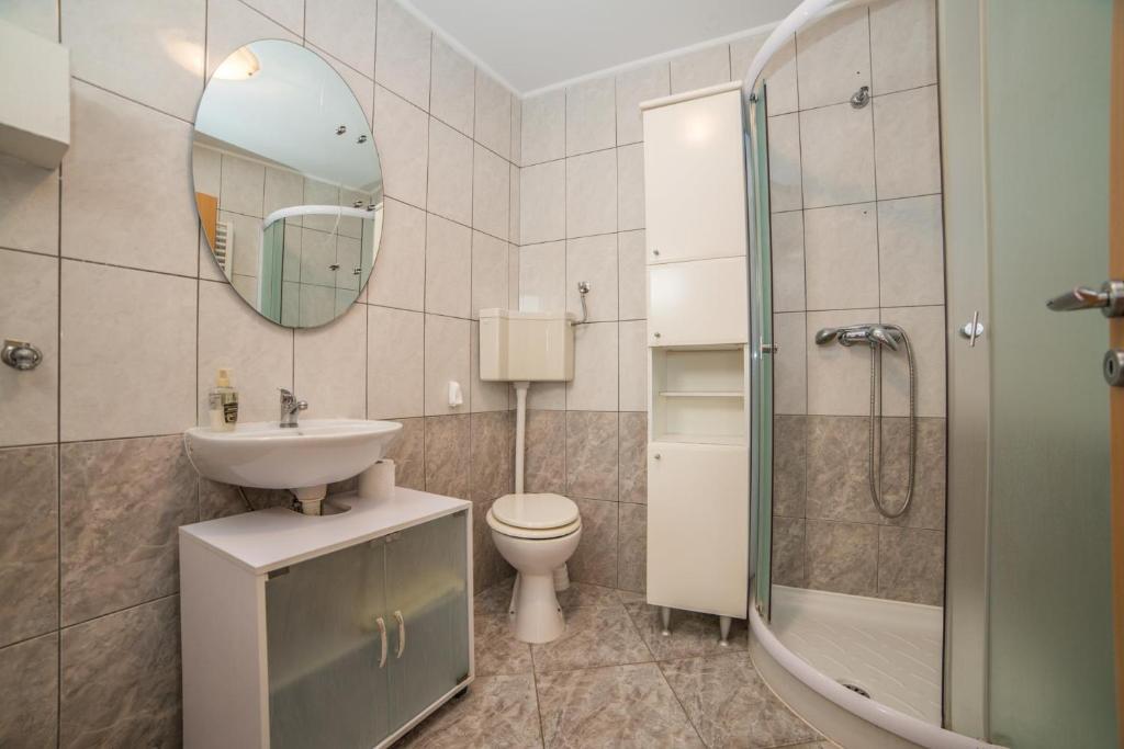 W łazience znajduje się toaleta z umywalką i lustro. w obiekcie Apartments Đurđa w Fažanie