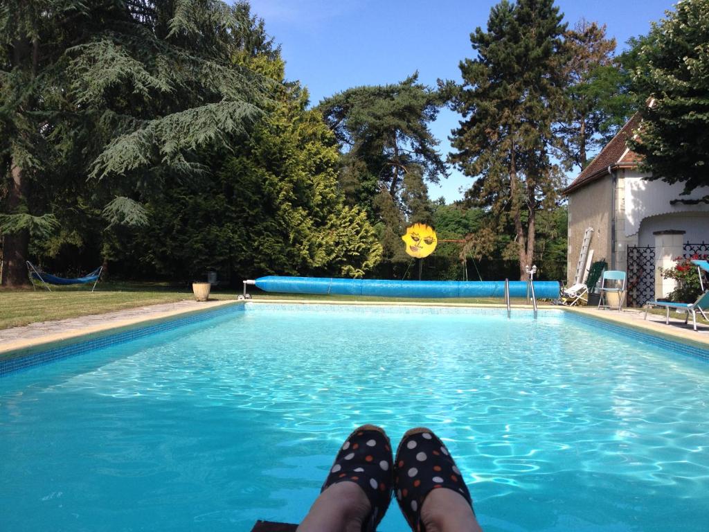 une personne se posant sur le côté d'une piscine dans l'établissement Maison des Arts Francueil, à Francueil