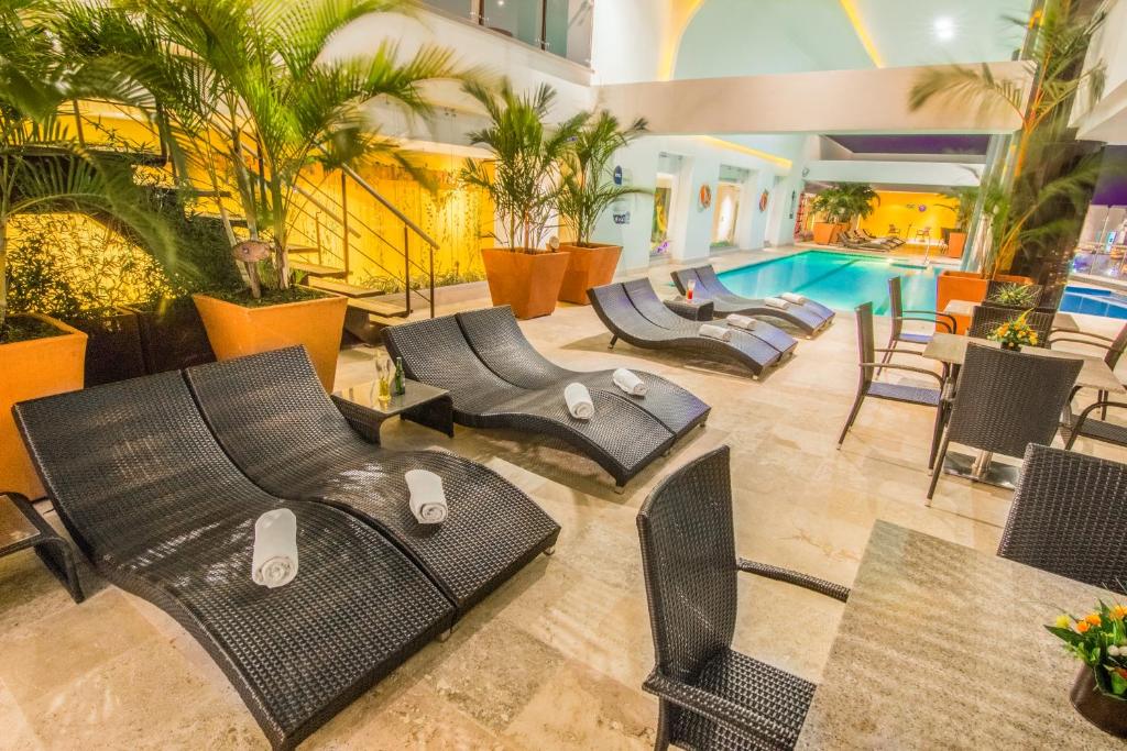 a hotel lobby with chairs and a swimming pool at GHL Hotel Grand Villavicencio in Villavicencio