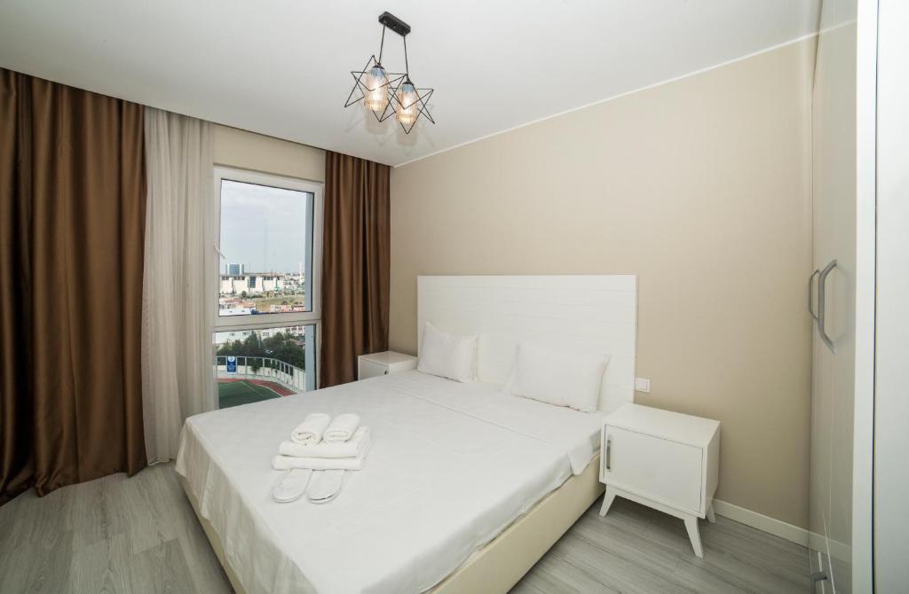 a white bedroom with a white bed and a window at Medproper Suites in Istanbul