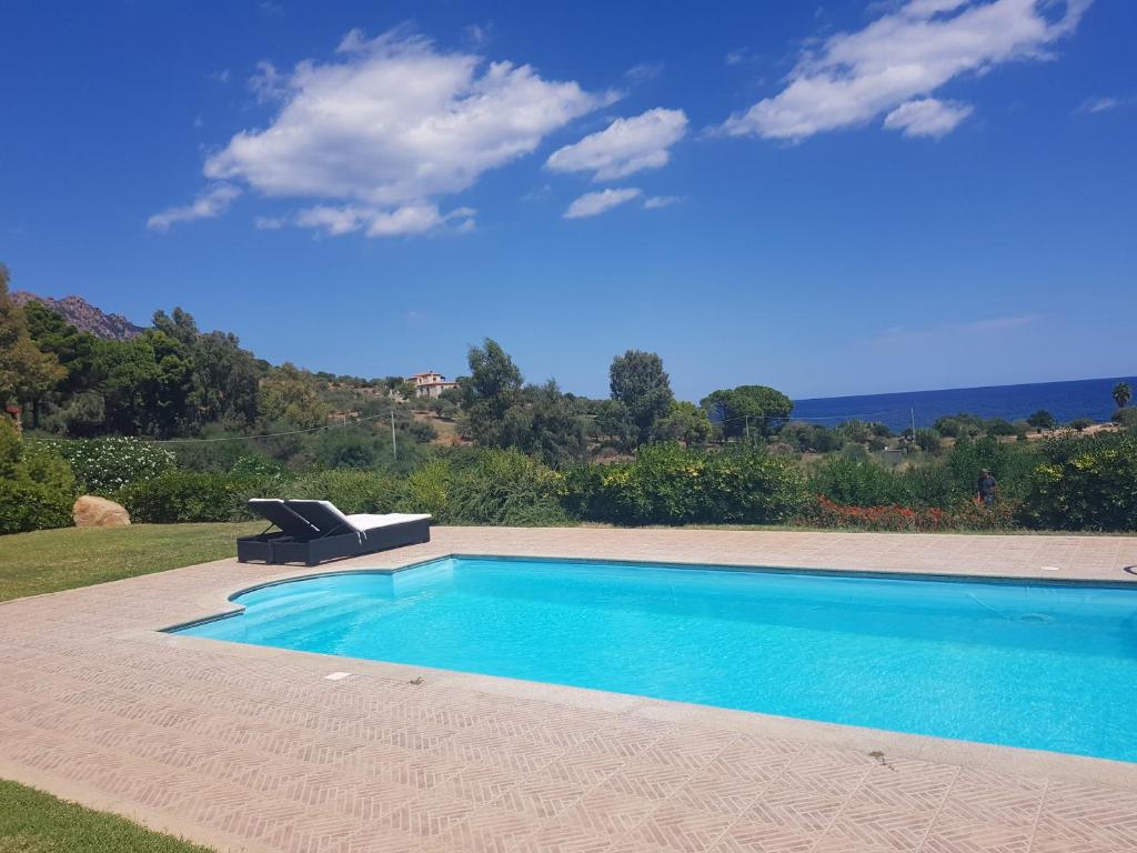 a swimming pool in a yard with a chair next to it at Abba Urci in Tertenìa