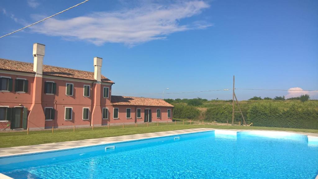 ein blauer Pool vor einem Haus in der Unterkunft Agriturismo Ca' Bonelli 1924 in Scardovari