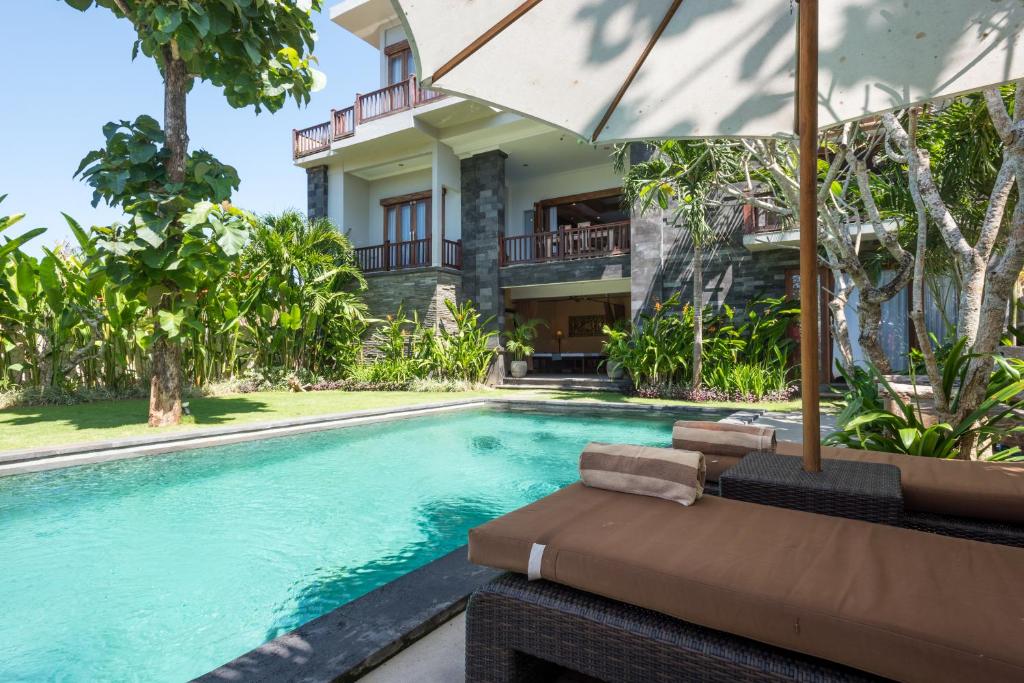 a swimming pool in front of a villa at Villa Melasti Wardana in Uluwatu