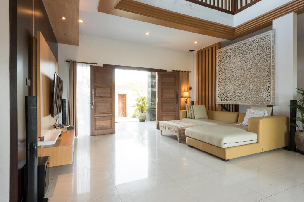 a living room with a couch and a tv at Villa Melasti Wardana in Uluwatu
