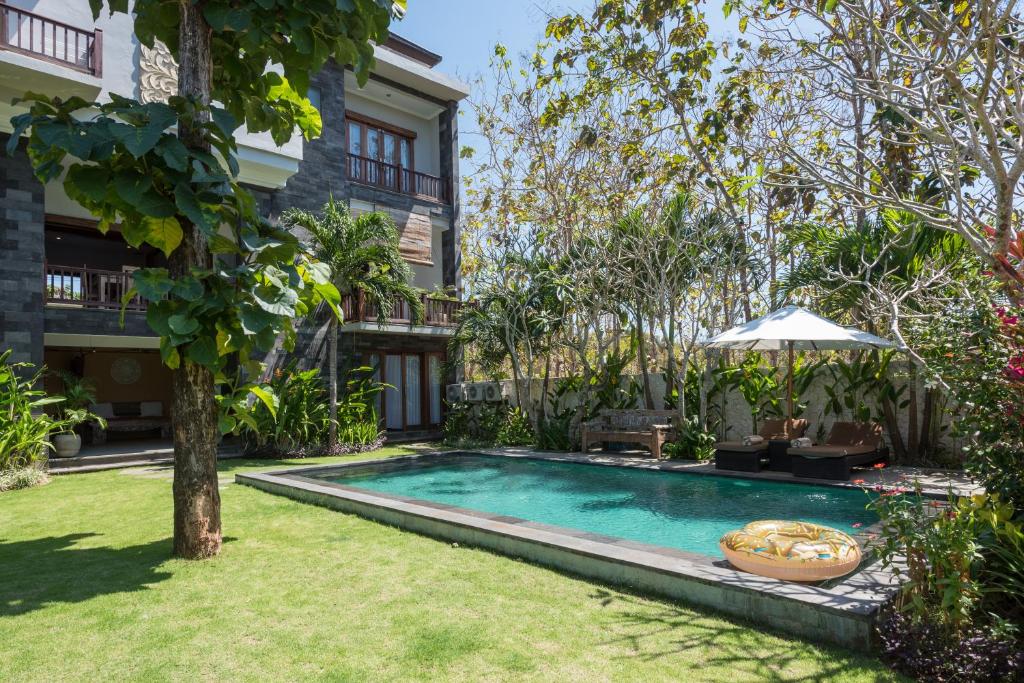 a swimming pool in the yard of a house at Villa Melasti Wardana in Uluwatu