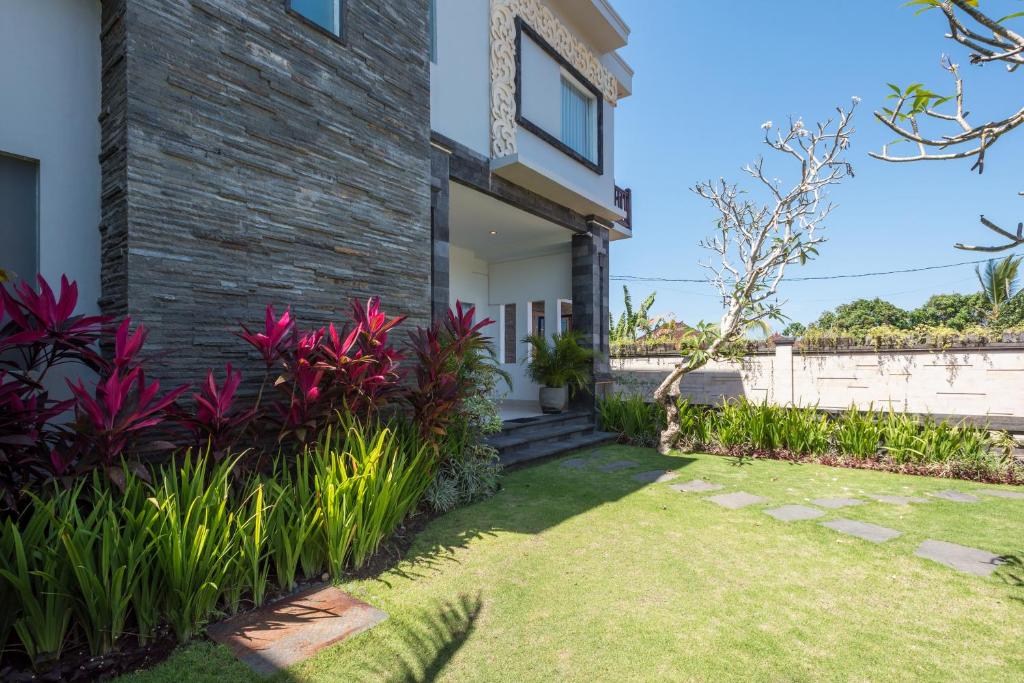 a house with a garden in front of it at Villa Melasti Wardana in Uluwatu