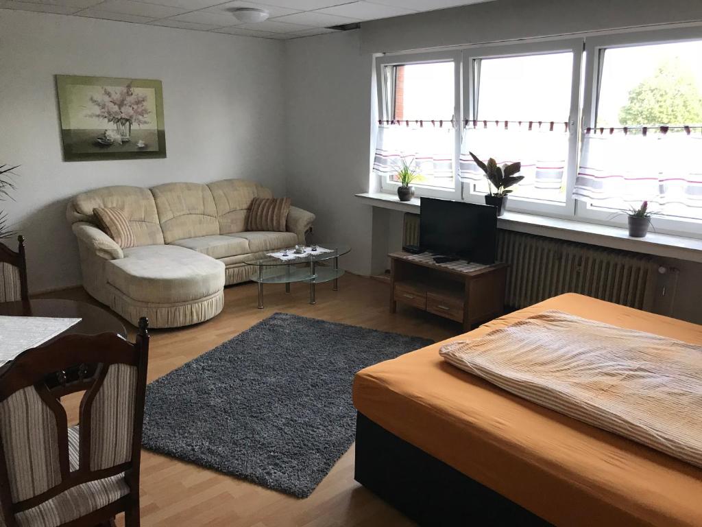 a living room with a couch and a tv at Landgasthof Schänzer in Voerde