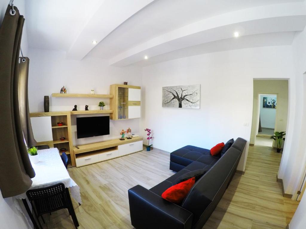 sala de estar con sofá y TV en Apartamentos Ainara, en Santa Cruz de Tenerife