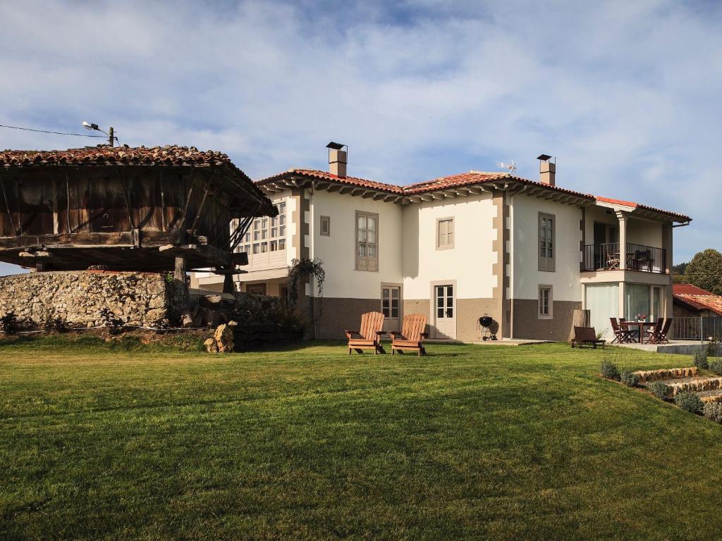 a large house with two chairs in a yard at el gran sueño Boutique Hotel & Apartamentos - Adults Only in Pintueles