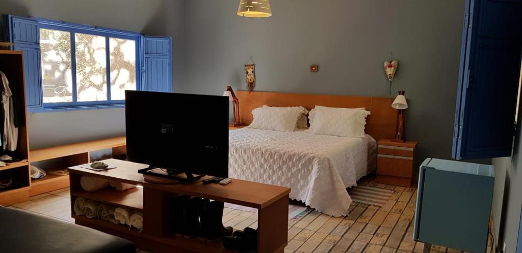 1 dormitorio con 1 cama y TV en una mesa en Orla Morada do Sol, en Pirenópolis