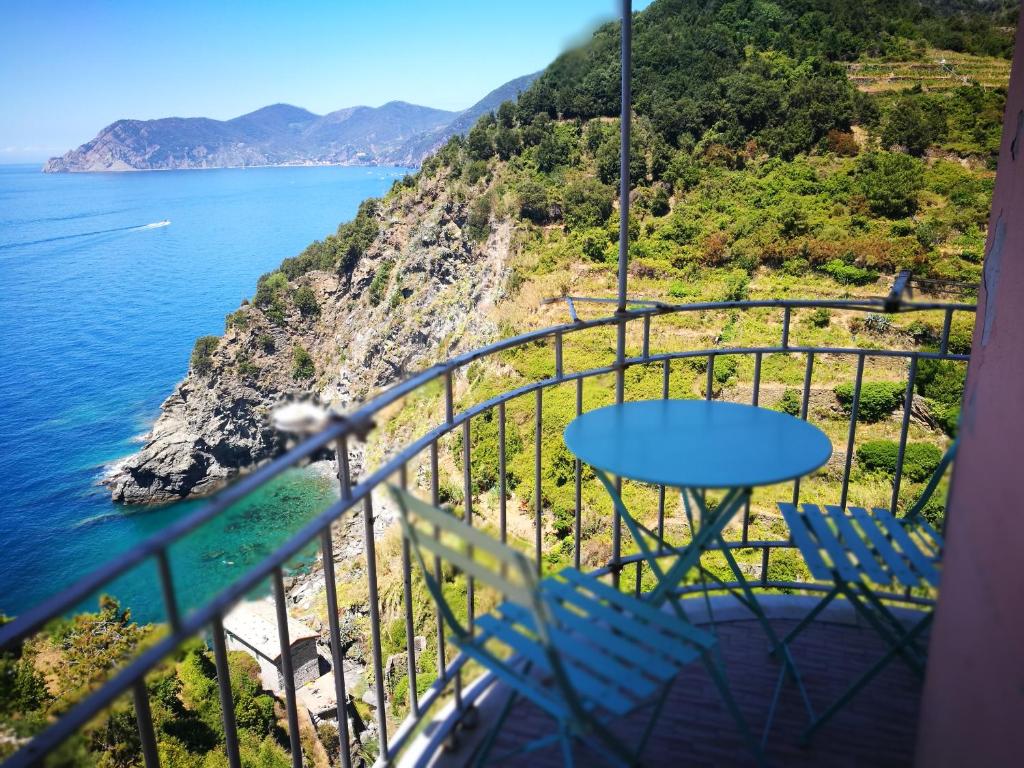 una mesa y sillas en un balcón con vistas al océano en Casa Belsito, en Corniglia
