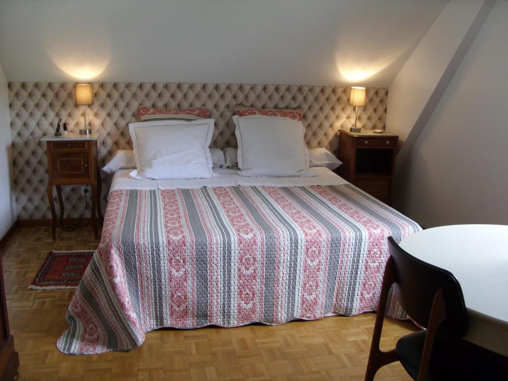 a bedroom with a bed and two pillows at Marcia Donatti-A l'Ombre des Coteaux Rio de Janeiro in Kaysersberg