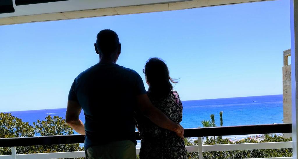 Ein Mann und eine Frau mit Blick auf den Ozean in der Unterkunft Estupendo Preciosas Vistas in Alicante