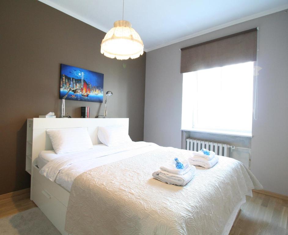 sypialnia z białym łóżkiem i ręcznikami w obiekcie Two-Bedroom Kalamaja Apartment w Tallinnie