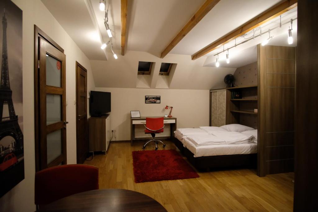 Schlafzimmer mit einem Bett und einem Schreibtisch mit einem roten Stuhl in der Unterkunft Apartamenty Wygoda Białystok in Białystok