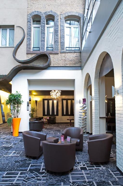 un hall avec des canapés et des tables dans un bâtiment dans l'établissement Mercure Strasbourg Centre Gare, à Strasbourg