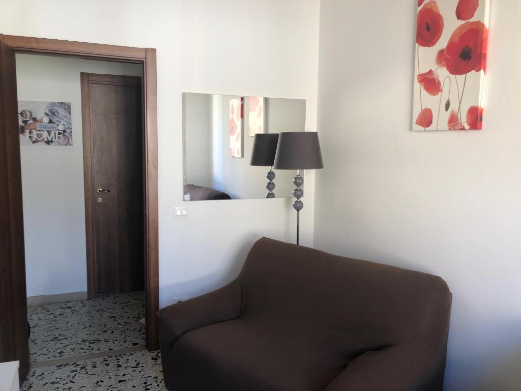 a living room with a brown chair and a mirror at Terni In Centro in Terni