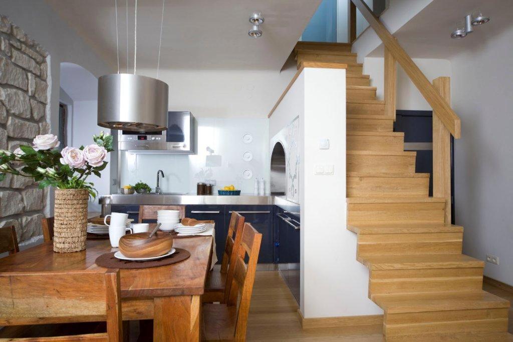 a kitchen and dining room with a table and a staircase at Apartament Rynkowy in Kazimierz Dolny