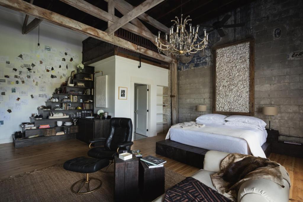 a bedroom with a large bed and a chandelier at GunRunner Boutique Hotel in Florence