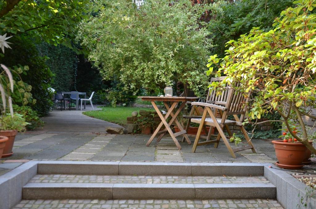 eine Terrasse mit einem Tisch und Stühlen im Garten in der Unterkunft Gästezimmer mit Garten in Fischeln in Krefeld