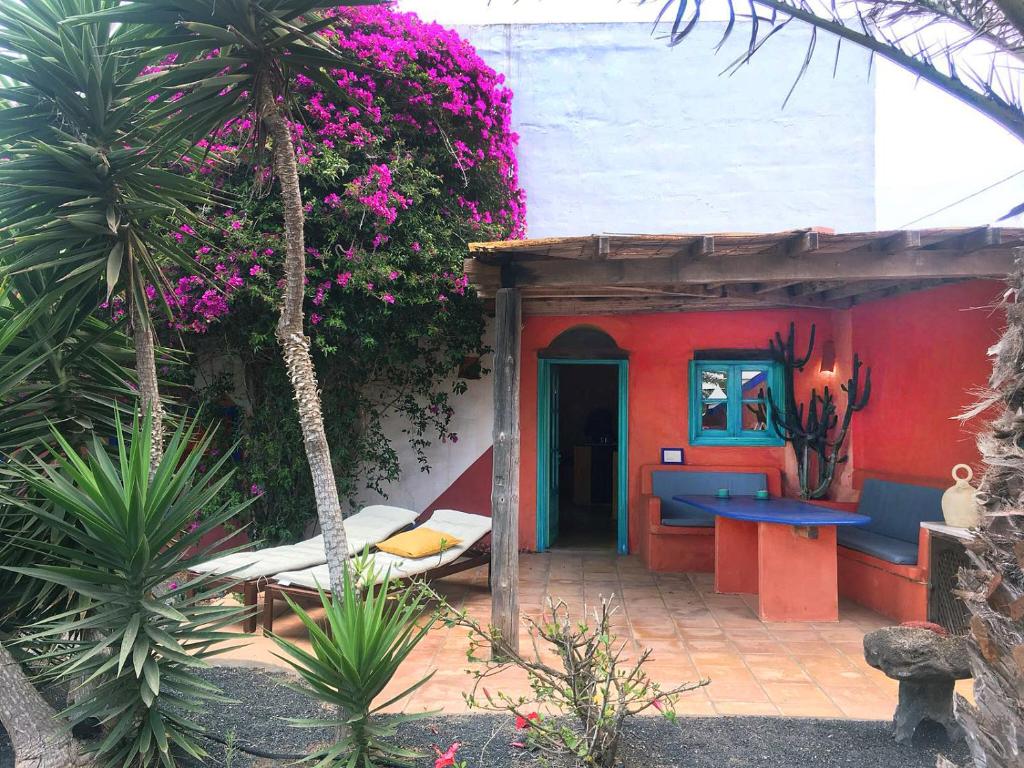 テギセにあるCasa Panama,in der Finca Mimosaのベッドと花が目の前にある家