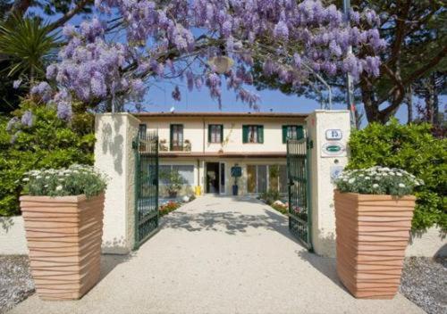 a house with purple flowers in front of a gate at Hotel La Pace in Forte dei Marmi