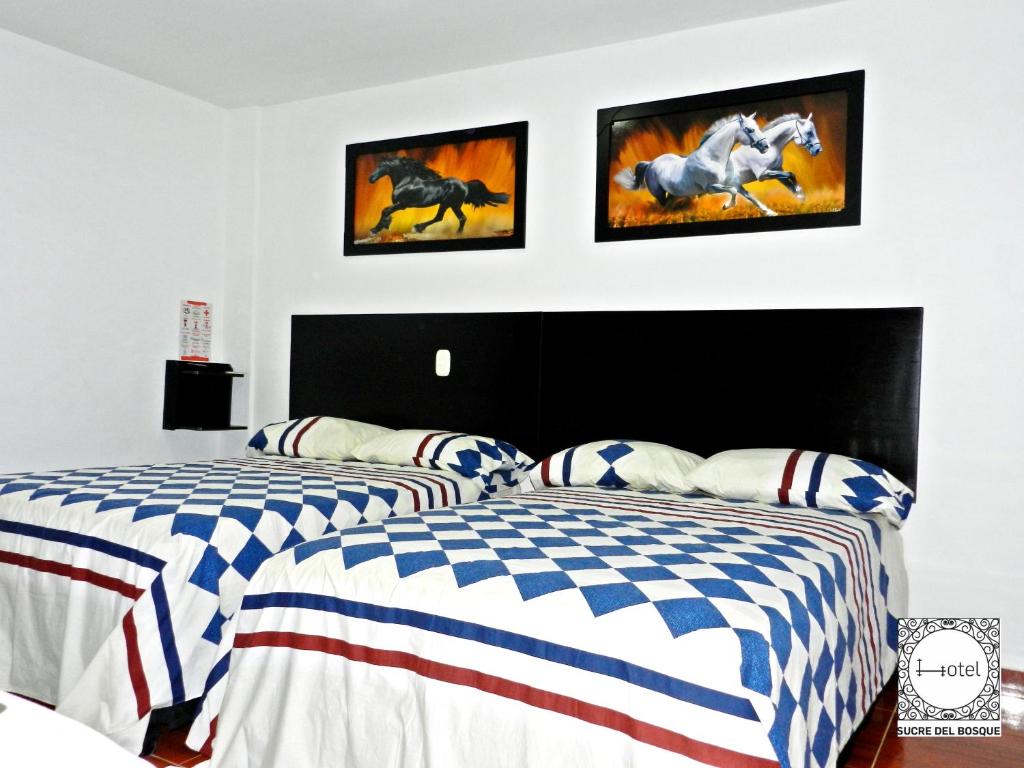 two beds in a bedroom with american flag at Hotel Sucre Del Bosque in Palmira