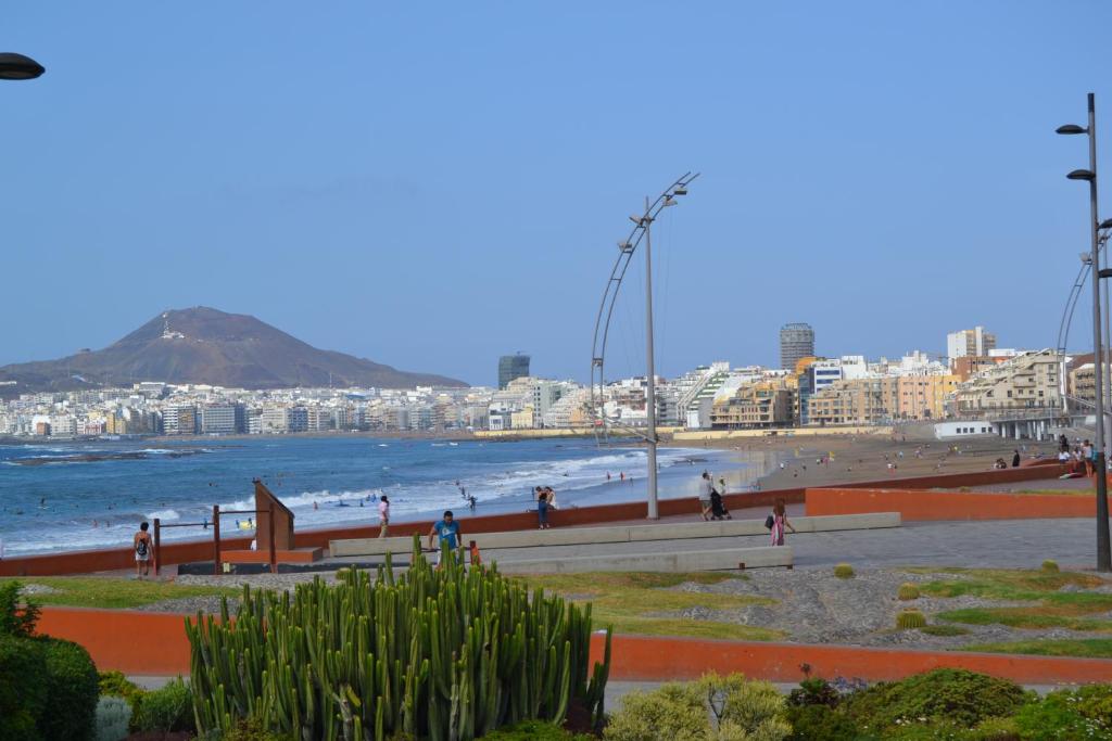 a beach with people walking on the sand and the ocean at MAGNIFICO Penthouse LAS PALMAS in Las Palmas de Gran Canaria