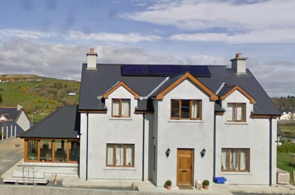 a large white house with a black roof at Luxury Skibbereen Town House in Skibbereen