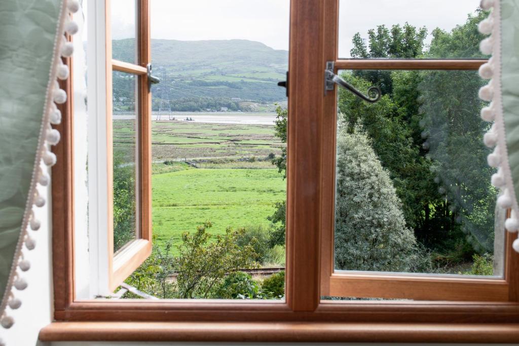 ein offenes Fenster mit Blick auf ein Feld in der Unterkunft Taldraeth - Old Vicarage Guest House in Penrhyndeudreath