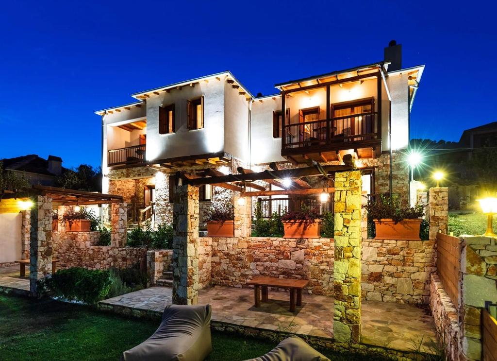 Redstone Luxury Villas في Theológos: منزل به جدار حجري في الليل
