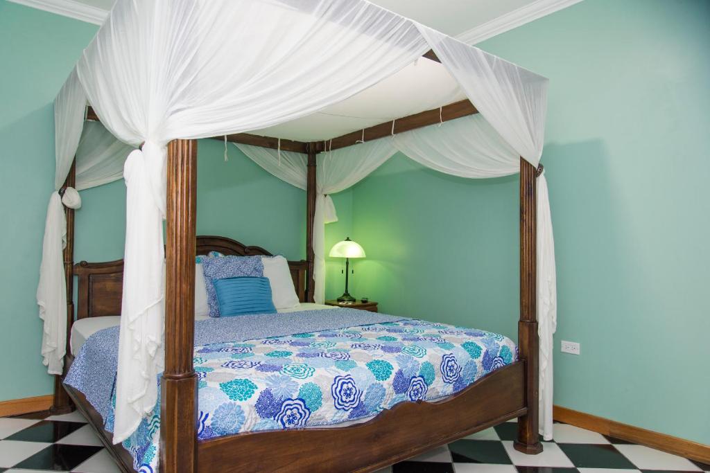 a bedroom with a canopy bed with a checkered floor at My Hotel in Puerto Rico in San Juan